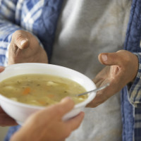 SDF recevant un bol de soupe